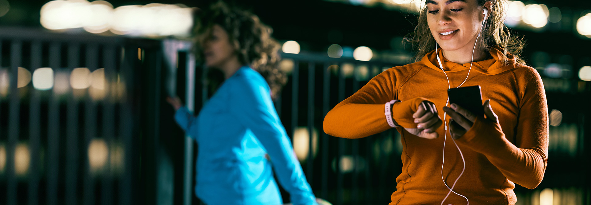 Jogger viewing smart watch and holding mobile device