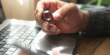 Person holding smart ring and smartphone